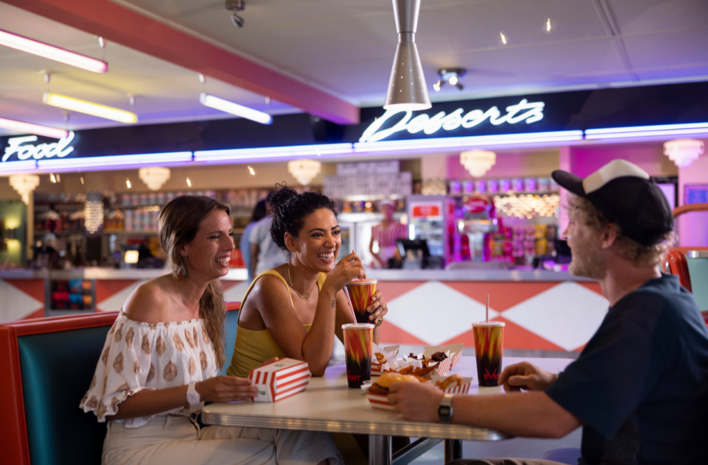 Friends enjoying pre-dinner food and drink at Retro decor at Skyline Drive In Blacktown diner.